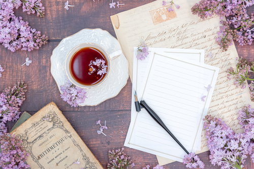 ライラックが添えられた便箋と万年筆、紅茶のティータイム