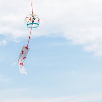 揺れる風鈴と夏の思い出を彩る赤い短冊と青空の写真