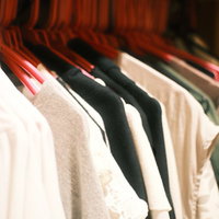 クローゼットのハンガーに掛けられた色とりどりの洋服の写真