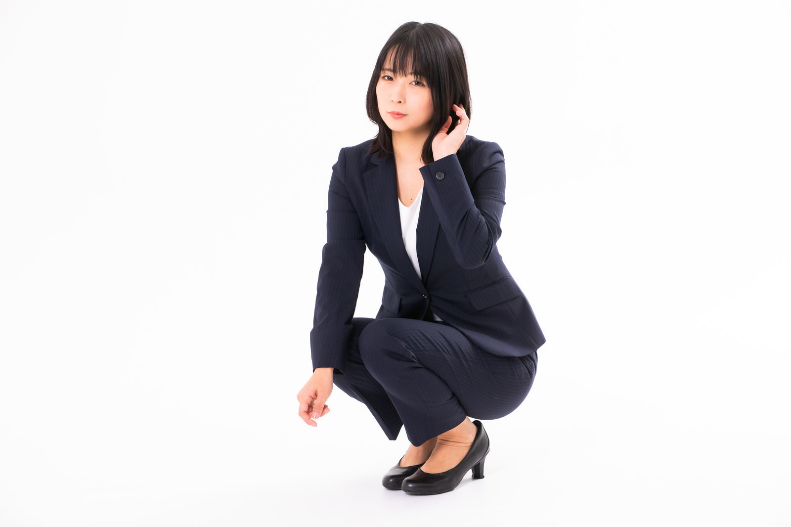 A female employee in a navy blue suit kneeling