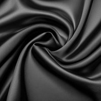 黒い光沢のある布地のドレープと流れるうねりの写真