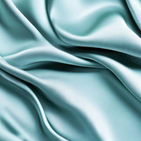 波打つ淡い青緑色の滑らかなサテン布のテクスチャーの写真