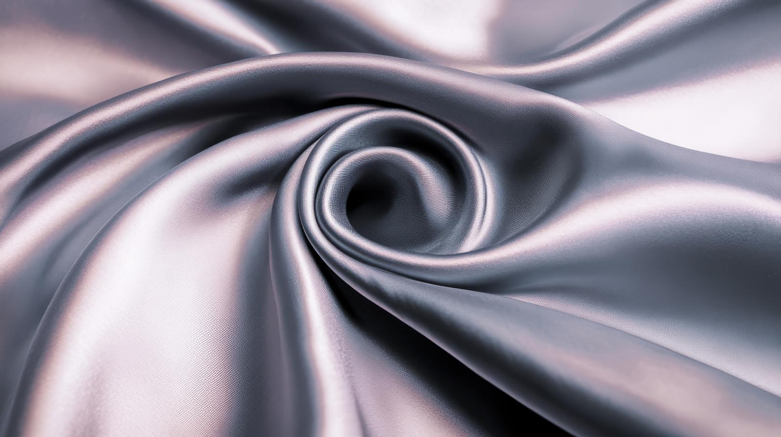 光沢のあるシルク素材が立体的に折り重なり、中央に渦巻き状の開口を作る形状