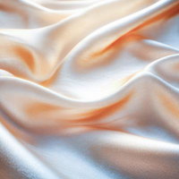 優しいオレンジと白に包まれたシルクのドレープの写真