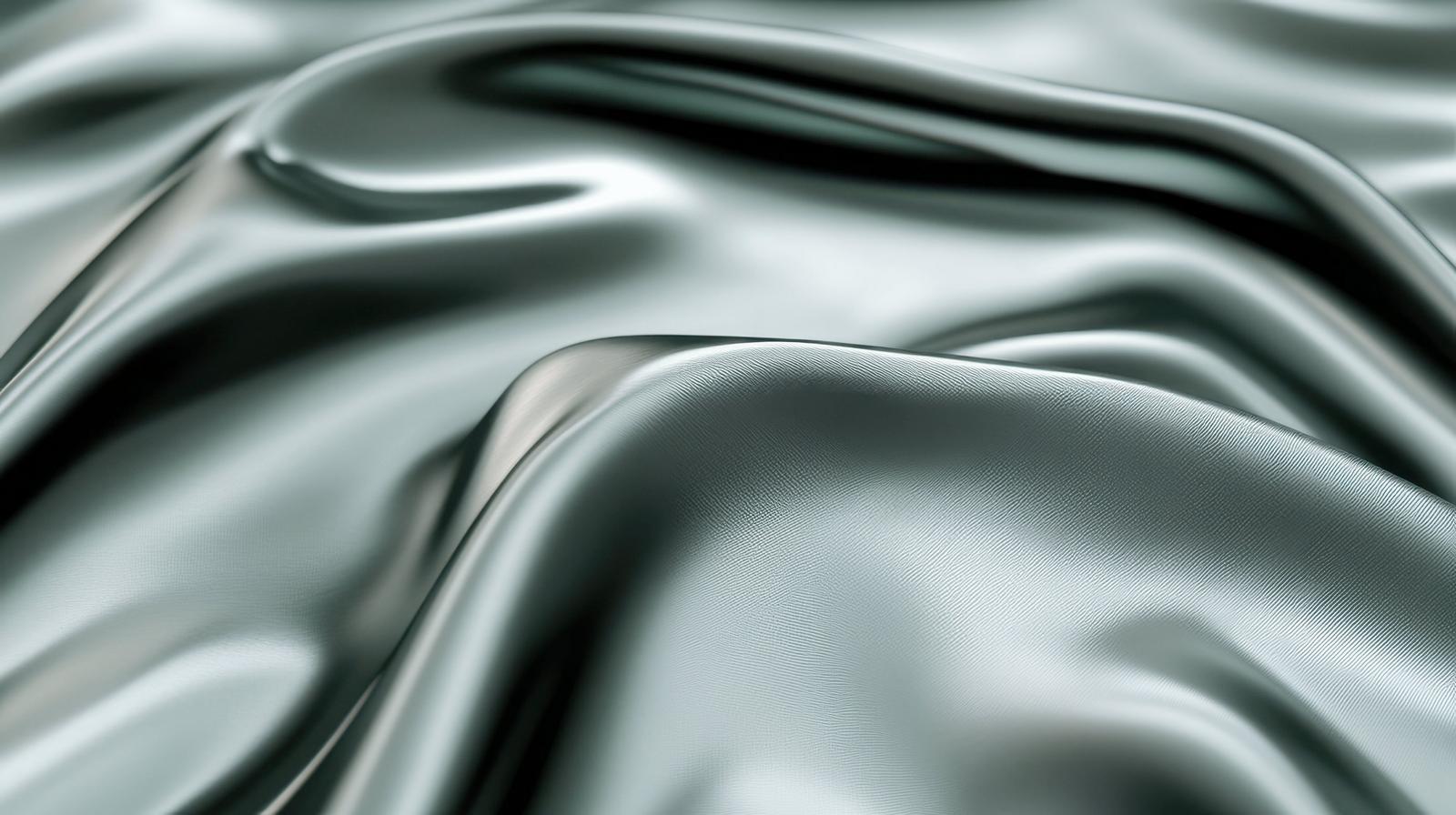 光沢のあるグレーとシルバーのサテン布地が波状にドレープされた画像