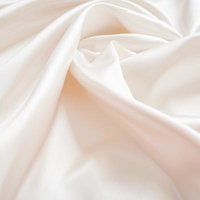 光沢のあるしわが寄った白い布生地のテクスチャーの写真