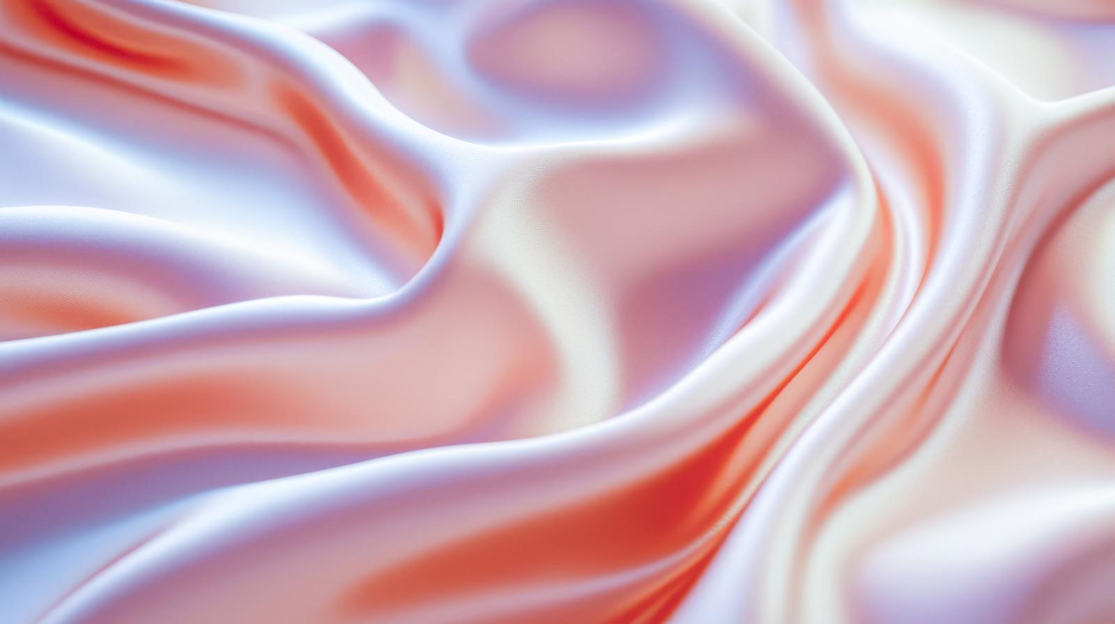 白からピンクへグラデーションするシルク素材が光沢を持ちながら波打つ