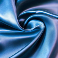 青いサテンの繊細なドレープが描く光沢の曲線美の写真