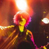 ライブステージで情熱的に演奏するギタリストと照明の写真