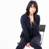 人差し指を顎に添えて誘惑するポーズをする女性社員の写真