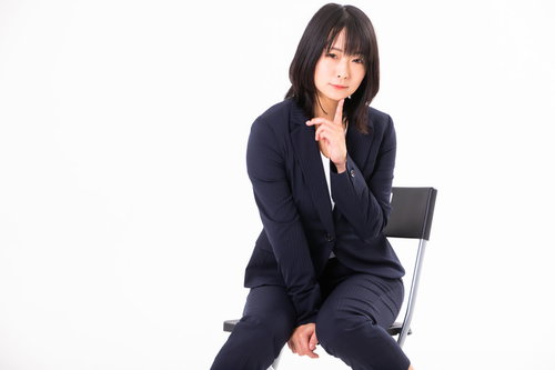 人差し指を顎に添えて誘惑するポーズをする女性社員