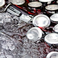 氷水に浸かって冷えたカラフルな缶ジュースの群れの写真