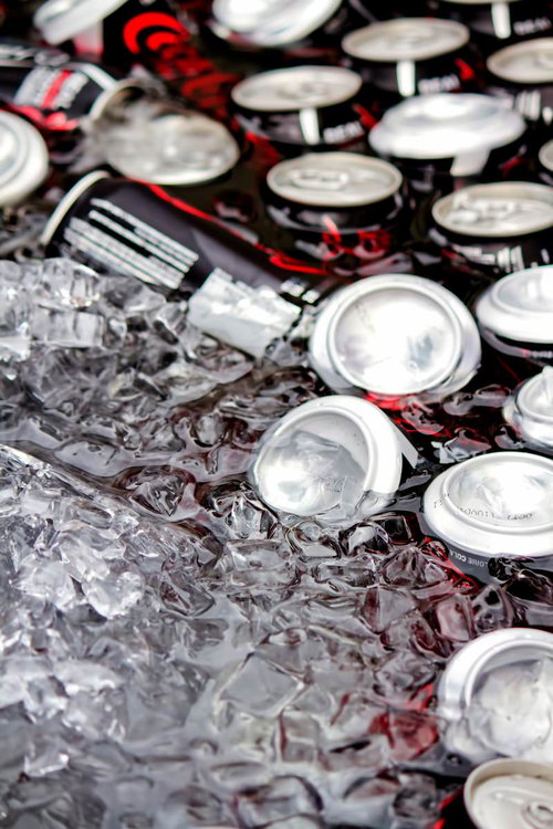 氷水に浸かって冷えたカラフルな缶ジュースの群れ