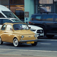 街中に停まるクラシックな黄色いフィアット500の写真
