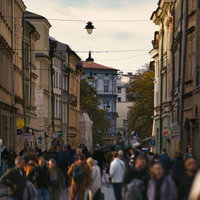 クラシックな建築と現代の賑わいが交差するクラクフの通りの写真