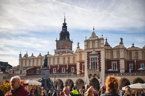 中世ヨーロッパの面影を残すクラクフ織物会館と時計塔、市民の憩いの広場