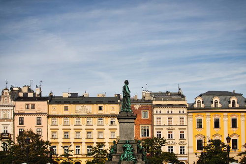 ポーランドのクラクフ中央市場広場に立つ銅像と歴史的建造物