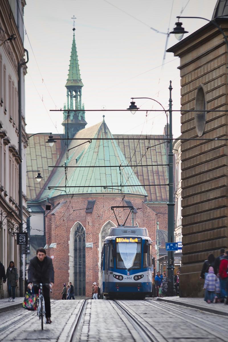 クラクフの路面電車と自転車、ゴシック建築に囲まれた街角