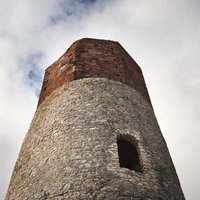 雲間に聳えるチェンストホバの古城の見張り塔の写真