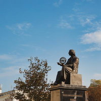 ワルシャワの科学者コペルニクス像、秋の青空に映える歴史的銅像の写真