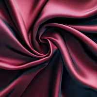 渦を巻くドレープが生み出すワインレッドのサテンファブリックの写真