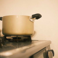 ガスコンロに置かれたステンレス製の鍋の写真