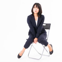 仕事終わりにほっと一息、にっこり笑う女性社員の写真