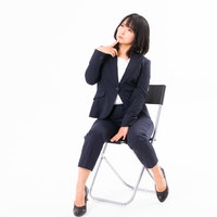 椅子に腰かけて疑問を抱く女性社員のビジネスポーズの写真