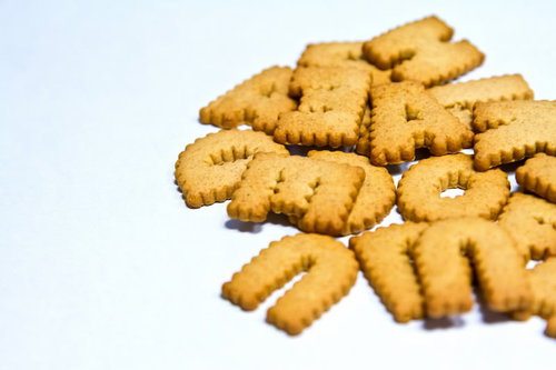 白い面に散らばったアルファベットの英語文字ビスケット