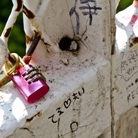 フェンスに括り付けられた恋人たちの落書きと南京錠の写真