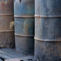 錆と汚れがついた工場にある古いドラム缶の写真