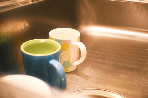 流しの木製カウンターに置かれたカップと洗い物