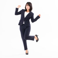 やったーと両手を上げて歓喜する女性社員のビジネスポーズの写真