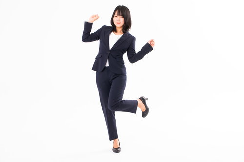 やったーと両手を上げて歓喜する女性社員のビジネスポーズ