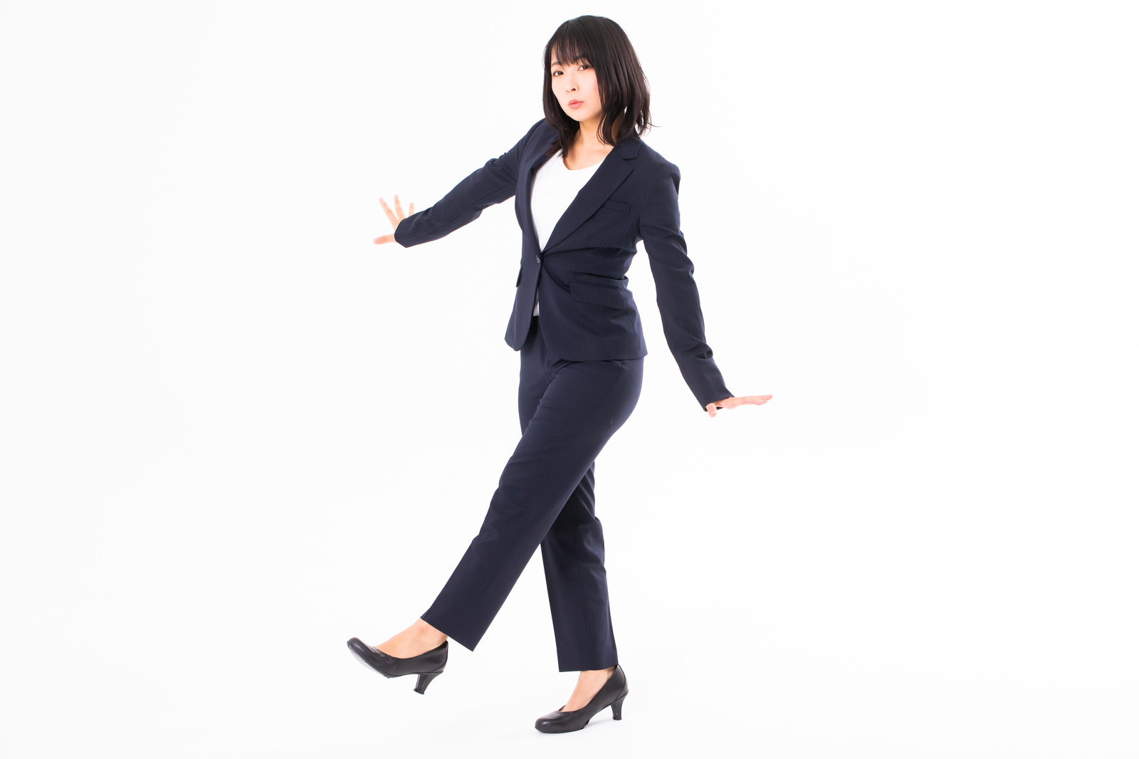 ダークスーツを着てヒールで正しい姿勢で歩く女性社員［モデル：にゃるる］