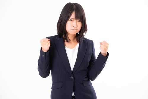 両手に力を込めるガッツポーズの女性社員のやる気満々の姿