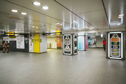 案内表示と人が行き交う渋谷駅の迷路のような電車乗り換え通路
