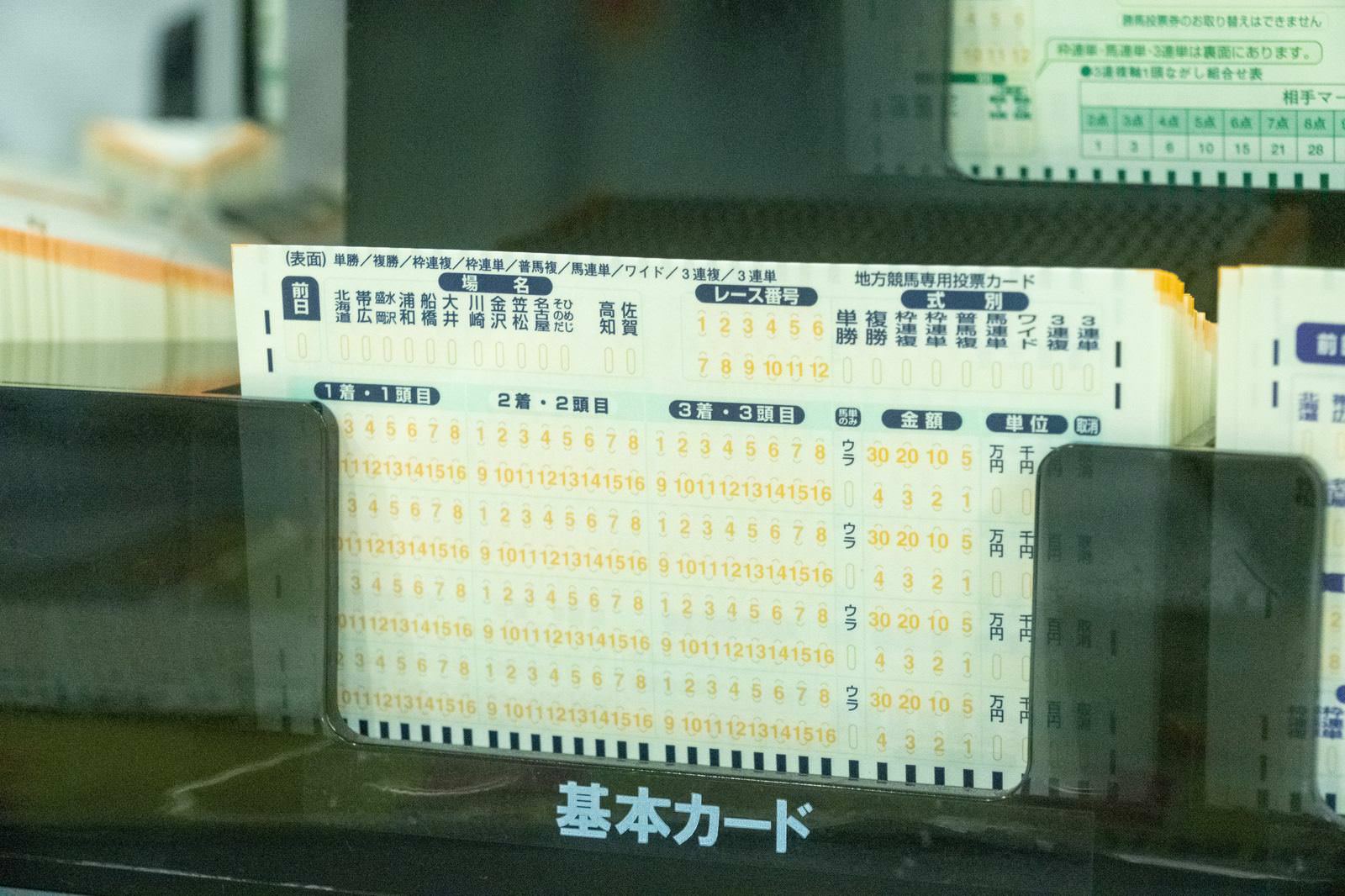 競馬場で使用される白い馬券カードが複数枚重なっている