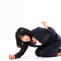 床を叩いて悔しがる女性社員の激しい仕草と怒りの感情表現の写真