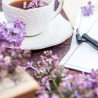 ライラックとティーカップが彩る書き始めた手紙の写真