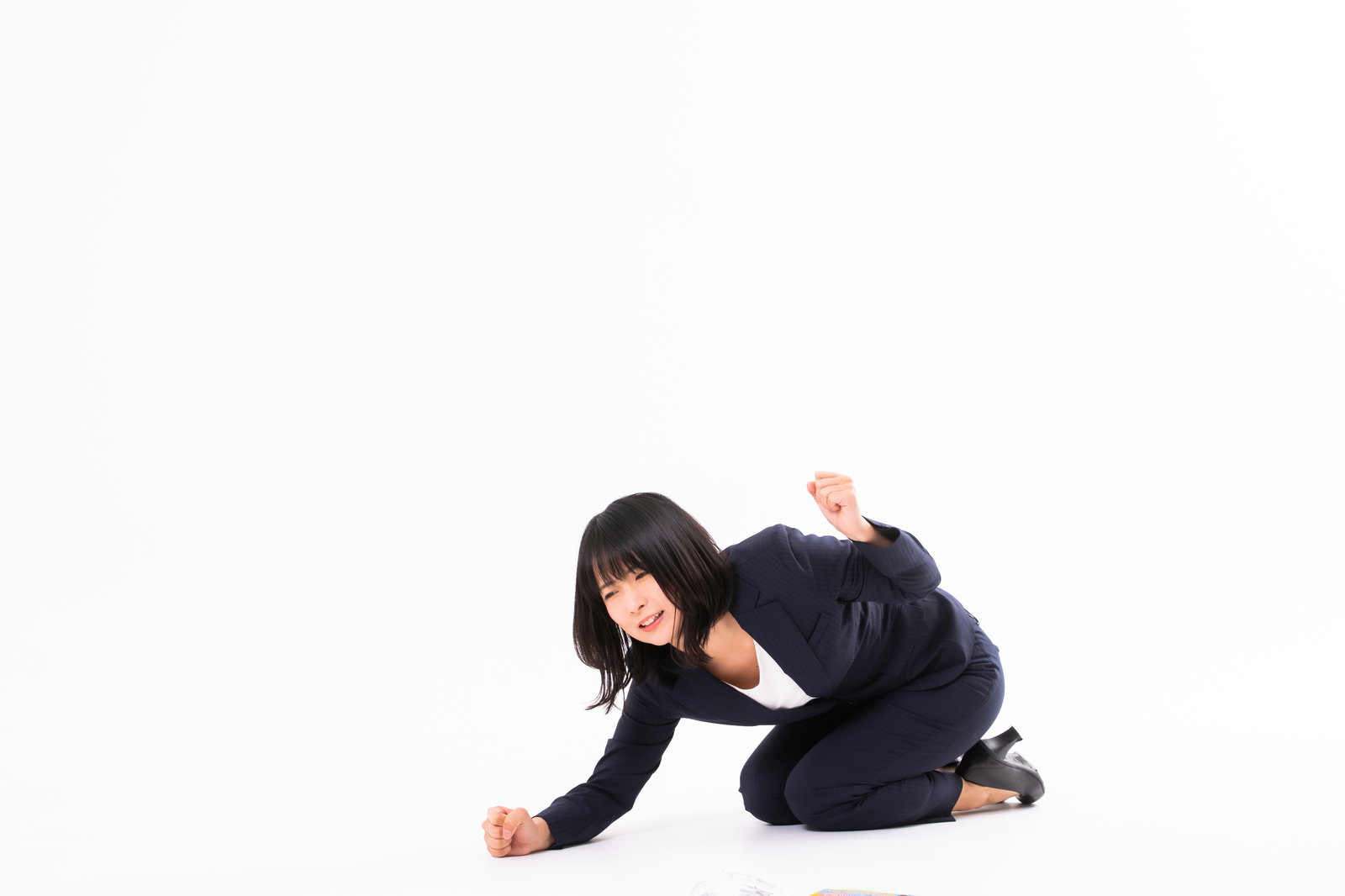 黒い服の女性が床に膝をついて拳で地面を叩いて悔しがっている様子［モデル：にゃるる］