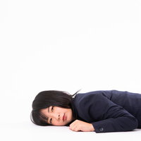 もうここから動きません・・・床に横たわる疲れ果てた女性の写真