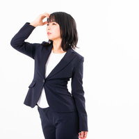 仕事ができそうなスーツ姿の女性会社員が手をかざして遠くを見つめるの写真
