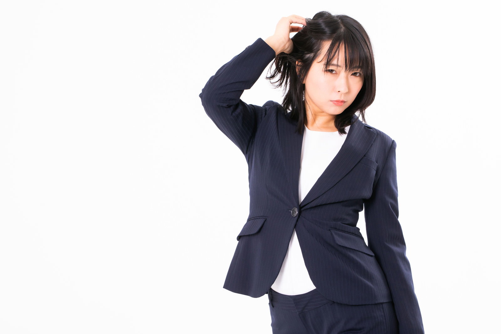 髪をかきあげるポーズをとるリクルートスーツ姿の女性［モデル：にゃるる］