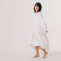 寂しげな表情で見つめる白いワンピースの女性の写真