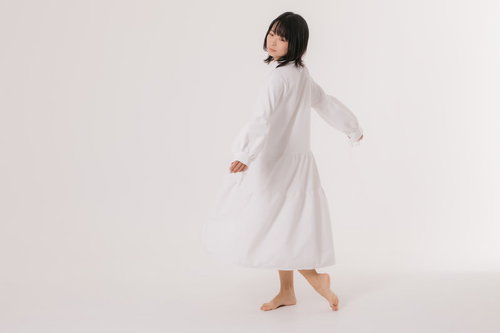 白いワンピースを着てくるりと回る女性モデルのポートレート