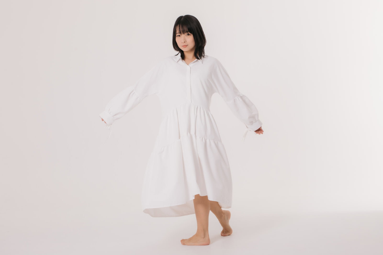 白いワンピースを着て振り向きながら照れている女性モデル［モデル：にゃるる］