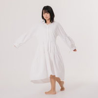 白いワンピースを試着中に振り向く女性モデルの写真