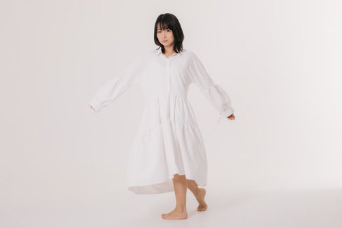 白いワンピースを試着中に振り向く女性モデル