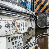 高輪橋架道路の架線と配管が複雑に張り巡らされた壁面の写真